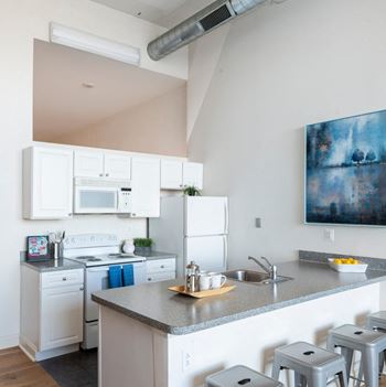 A kitchen with exposed HVAC ductwork